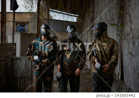 An armed group of three people practice with weapons on a training field outdoor An armed group of three people practice with weapons on a training field outdoor 141605442