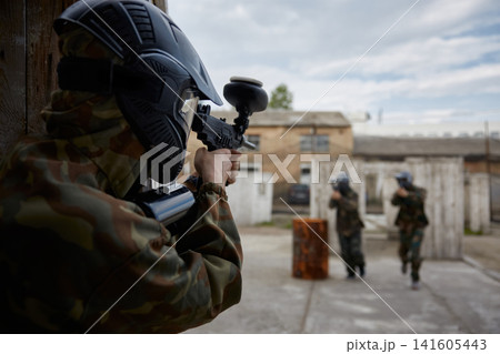 A Soldier is taking aim while teammates advance during tactical field training A Soldier is taking aim while teammates advance during tactical field training 141605443