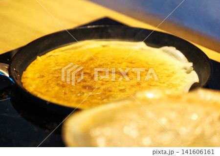 Close up of thin crepe frying in pan Close up of thin crepe frying in pan 141606161