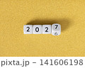 Year 2026 changing to 2027 on dice, glitter festive golden background. New year change concept 141606198