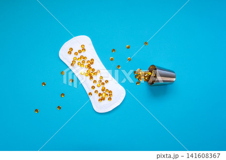 Sanitary Pad with Gold Sequins Pouring from Metal Cup, Heavy Urinary Incontinence Concept Sanitary Pad with Gold Sequins Pouring from Metal Cup, Heavy Urinary Incontinence Concept 141608367