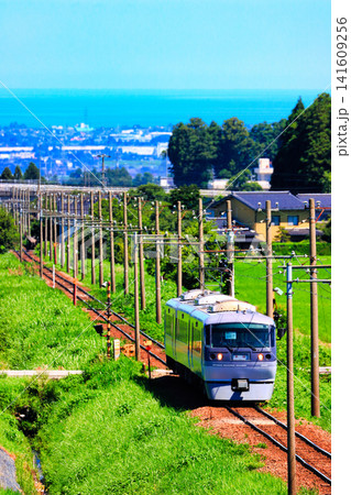 富山湾と街並みを望む富山地方鉄道20020形「ニューレッドアロー」(立山線・縦構図) 富山湾と街並みを望む富山地方鉄道20020形「ニューレッドアロー」(立山線・縦構図) 141609256