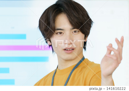 プレゼンする若いカジュアルな服の日本人男性の顔のアップ プレゼンする若いカジュアルな服の日本人男性の顔のアップ 141610222