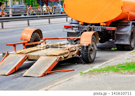 Truck with trailer parked on roadside during daytime near busy street. Truck with trailer parked on roadside during daytime near busy street. 141610711