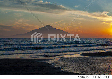 北海道の浜辺から眺める利尻島の夕焼け、波打つ海と暮れゆく空 141610811