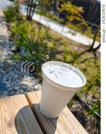公園のベンチに置かれたテイクアウト用のホットコーヒー 公園のベンチに置かれたテイクアウト用のホットコーヒー 141610978
