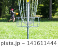 Man throwing frisbee playing disc golf 141611444