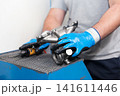 Automotive worker holding new part of car engine 141611446