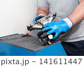 Automotive worker holding new part of car engine 141611447