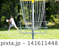 Man throwing frisbee playing disc golf in the park 141611448