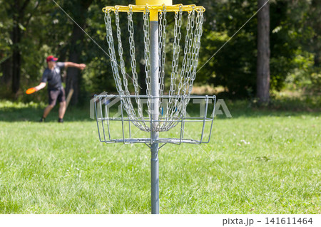 Man throwing frisbee playing disc golf 141611464