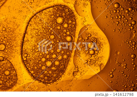 Gold and amber oil bubbles floating in water creating an abstract macro background texture Gold and amber oil bubbles floating in water creating an abstract macro background texture 141612798