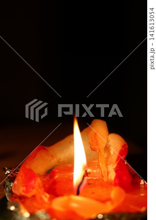 A burning candle in the form of a figurine. 141613054