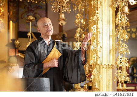 寺院の本堂で数珠を手に法話をする僧侶 寺院の本堂で数珠を手に法話をする僧侶 141613631