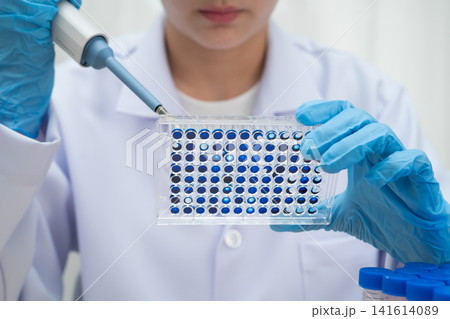 Scientist with cell culture in sample micro plate for research in science laboratory. Scientist with cell culture in sample micro plate for research in science laboratory. 141614089