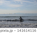 湘南の海でサーフィンに向かう男性とウィンドサーフィンが広がる風景 141614116