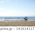 湘南のビーチでサーフボードを持って歩く人々と穏やかな海の風景 141614117