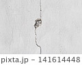 cracked white concrete wall texture with damaged cement surface and hole 141614448