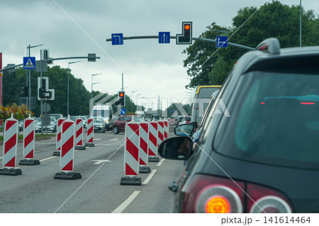 Traffic Congestion at Urban Roadworks with Temporary Lane Closures and Red Traffic Signal Ahead Scene 141614464