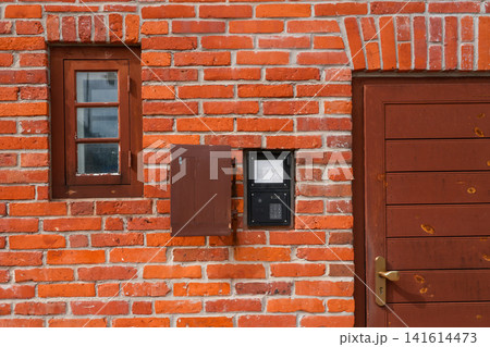 Traditional Red Brick House Entrance with Wooden Door, Window and Audio Intercom Security Access System 141614473