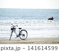 ビーチに停めた自転車と海に向かうサーファーのある湘南の風景 141614599