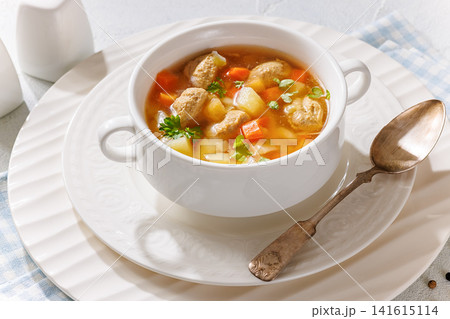 Old fashioned poultry meatball soup in clear broth Old fashioned poultry meatball soup in clear broth 141615114