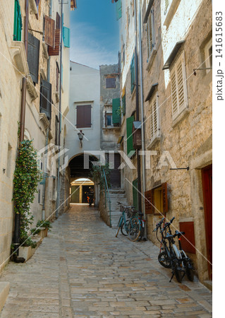 Narrow cobbled street with archway and bicycles in Rovinj, Croatia. Narrow cobbled street with archway and bicycles in Rovinj, Croatia. 141615683