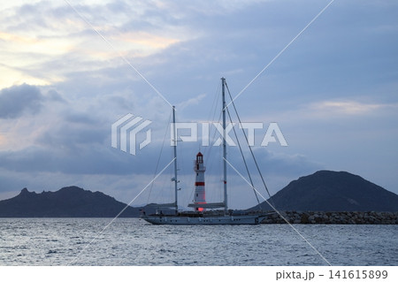 Seascape at sunshine. Lighthouse and sailings on the coast. Seaside town of Turgutreis and spectacular sunshine Seascape at sunshine. Lighthouse and sailings on the coast. Seaside town of Turgutreis and spectacular sunshine 141615899