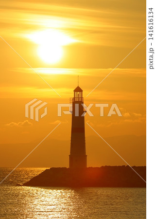 Seascape at sunshine. Lighthouse and sailings on the coast. Seaside town of Turgutreis and spectacular sunshine Seascape at sunshine. Lighthouse and sailings on the coast. Seaside town of Turgutreis and spectacular sunshine 141616134