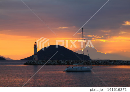 Seascape at sunshine. Lighthouse and sailings on the coast. Seaside town of Turgutreis and spectacular sunshine Seascape at sunshine. Lighthouse and sailings on the coast. Seaside town of Turgutreis and spectacular sunshine 141616271