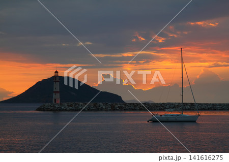 Seascape at sunshine. Lighthouse and sailings on the coast. Seaside town of Turgutreis and spectacular sunshine 141616275