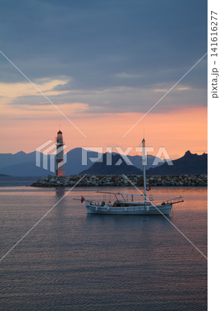 Seascape at sunshine. Lighthouse and sailings on the coast. Seaside town of Turgutreis and spectacular sunshine Seascape at sunshine. Lighthouse and sailings on the coast. Seaside town of Turgutreis and spectacular sunshine 141616277