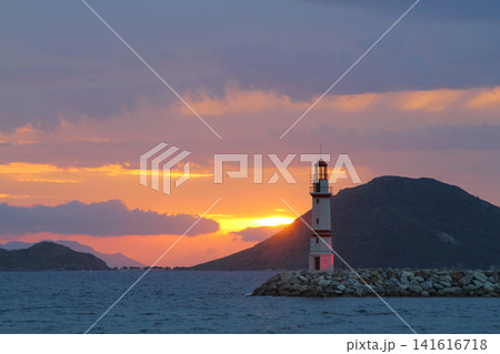 Seascape at sunshine. Lighthouse and sailings on the coast. Seaside town of Turgutreis and spectacular sunshine Seascape at sunshine. Lighthouse and sailings on the coast. Seaside town of Turgutreis and spectacular sunshine 141616718