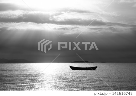 Sunset in the sea with a boat. A picture of a small boat with a beautiful sunset background. 141616745