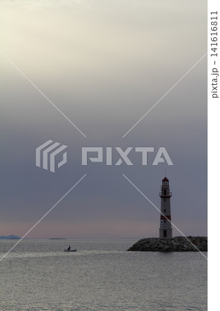 Seascape at sunshine. Lighthouse and sailings on the coast. Seaside town of Turgutreis and spectacular sunshine Seascape at sunshine. Lighthouse and sailings on the coast. Seaside town of Turgutreis and spectacular sunshine 141616811
