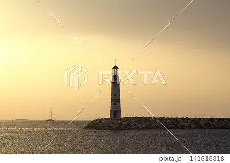 Seascape at sunshine. Lighthouse and sailings on the coast. Seaside town of Turgutreis and spectacular sunshine Seascape at sunshine. Lighthouse and sailings on the coast. Seaside town of Turgutreis and spectacular sunshine 141616818