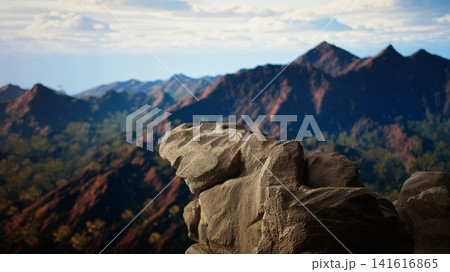 Rugged rocky ledge overlooks a breathtaking mountain range, offering a picturesque view of the wilderness. Adventure destination for hikers and nature lovers seeking fresh air and freedom. Rugged rocky ledge overlooks a breathtaking mountain range, offering a picturesque view of the wilderness. Adventure destination for hikers and nature lovers seeking fresh air and freedom. 141616865
