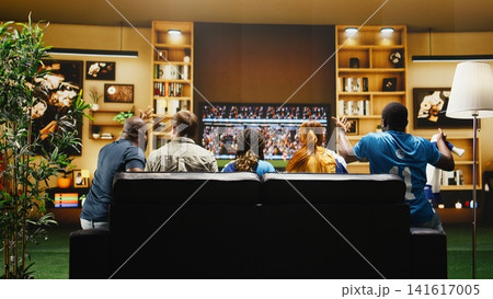 Football fans watch tense football match from sofa, having frantic reactions to missed chance on TV. Supporters at home agitated by referee decisions in dramatic soccer game Football fans watch tense football match from sofa, having frantic reactions to missed chance on TV. Supporters at home agitated by referee decisions in dramatic soccer game 141617005