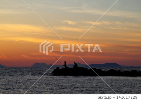 Tourists on holiday in the famous resort town of Bodrum spend time fishing at sunset. Tourists on holiday in the famous resort town of Bodrum spend time fishing at sunset. 141617229