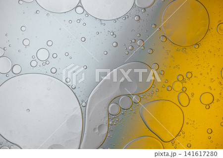 Oil and water bubbles mixing, creating an abstract yellow and gray fluid texture Oil and water bubbles mixing, creating an abstract yellow and gray fluid texture 141617280