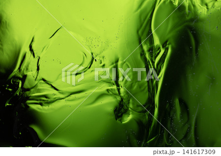 Viscous green liquid with swirling patterns creates an abstract background Viscous green liquid with swirling patterns creates an abstract background 141617309