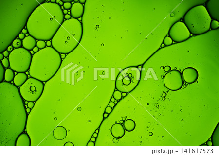 Oil drops and water creating an abstract green liquid pattern with bubbles Oil drops and water creating an abstract green liquid pattern with bubbles 141617573