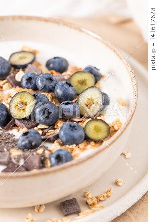 Healthy yogurt bowl with fresh blueberries granola and chia seeds in a rustic ceramic dish for a nutritious and delicious morning meal Healthy yogurt bowl with fresh blueberries granola and chia seeds in a rustic ceramic dish for a nutritious and delicious morning meal 141617628