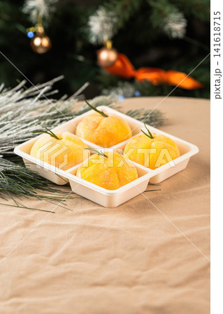 Healthy New Year mochi desserts shaped like mandarins in white tray on festive background low calorie natural ingredients Japanese wagashi style sweets Healthy New Year mochi desserts shaped like mandarins in white tray on festive background low calorie natural ingredients Japanese wagashi style sweets 141618715