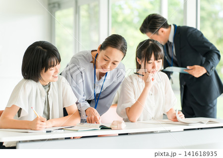 塾・学童で勉強・学校で授業・夏期講習をする小学生の子供(教育)と塾教師 塾・学童で勉強・学校で授業・夏期講習をする小学生の子供(教育)と塾教師 141618935