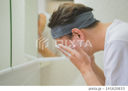 洗面台でヘアバンドをして泡洗顔をする40代男性 洗面台でヘアバンドをして泡洗顔をする40代男性 141620633