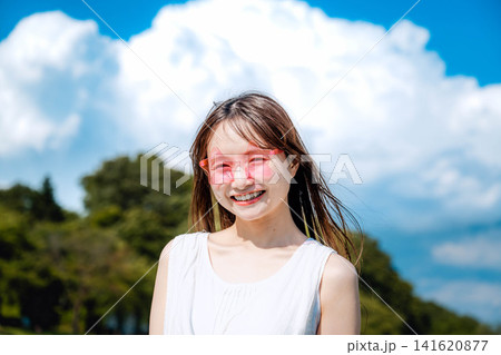 夏の青空の下で笑顔を見せる女性 141620877