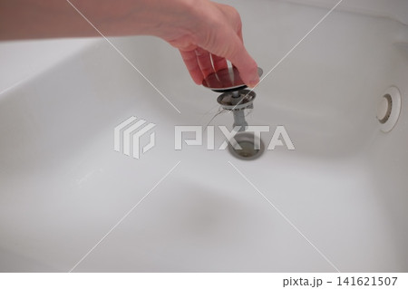 洗面所の排水口掃除をする女性の手 141621507