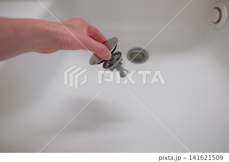 洗面所の排水口掃除をする女性の手 141621509