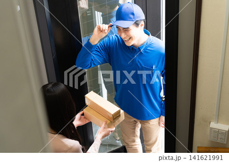 若い女性と宅配業者の荷物の受け渡し ライフスタイルイメージ 若い女性と宅配業者の荷物の受け渡し ライフスタイルイメージ 141621991